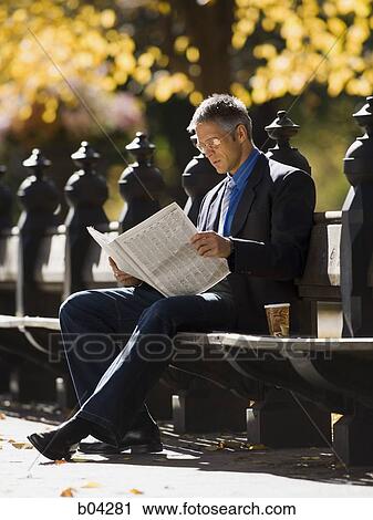 Businessman on wooden bench outdoors with newspaper View Large Photo Image Stock Image - Businessman on wooden bench outdoors with newspaper. Fotosearch