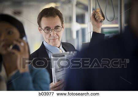 Businessman reading on city bus or subway View Large Photo Image Stock Photo - Businessman reading on city bus or subway. Fotosearch