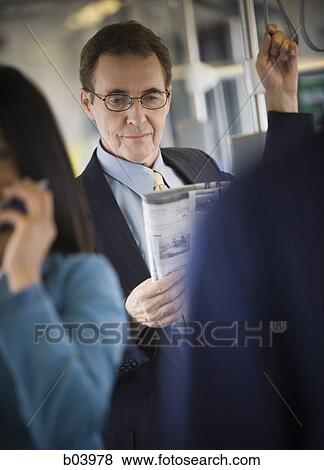 Businessman reading on city bus or subway View Large Photo Image Stock Photo - Businessman reading on city bus or subway. Fotosearch