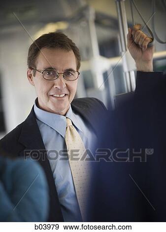Businessman standing on city bus or subway View Large Photo Image Stock Photo - Businessman standing on city bus or subway. Fotosearch