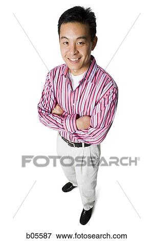 Businessman standing with arms crossed looking up View Large Photo Image Stock Photo - Businessman standing with arms crossed looking up. Fotosearch