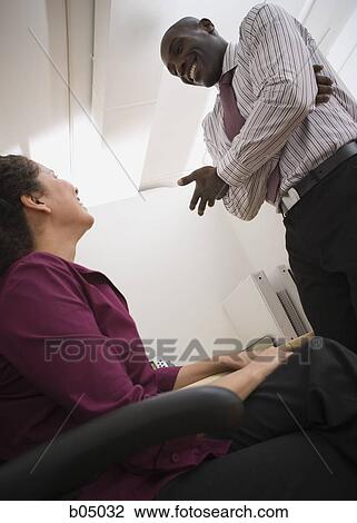 Businessman talking with woman in cubicle View Large Photo Image Stock Image - Businessman talking with woman in cubicle. Fotosearch