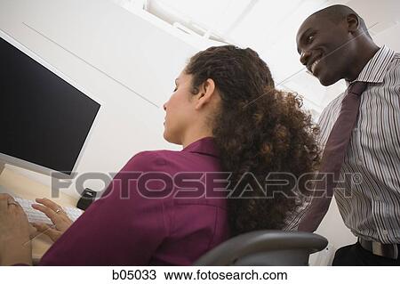 Businessman talking with woman in cubicle View Large Photo Image Stock Image - Businessman talking with woman in cubicle. Fotosearch