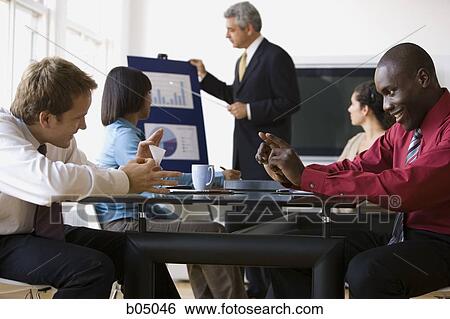 Businessmen playing during meeting presentation View Large Photo Image Stock Photograph - Businessmen playing during meeting presentation. Fotosearch