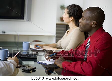 Businesspeople making notes at meeting View Large Photo Image Stock Image - Businesspeople making notes at meeting. Fotosearch