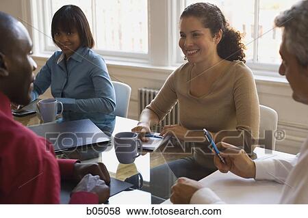 Businesspeople smiling at meeting View Large Photo Image Stock Photo - Businesspeople smiling at meeting. Fotosearch