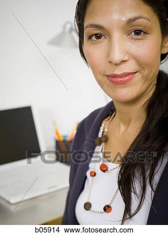 Businesswoman with laptop in background View Large Photo Image Picture - Businesswoman with laptop in background. Fotosearch