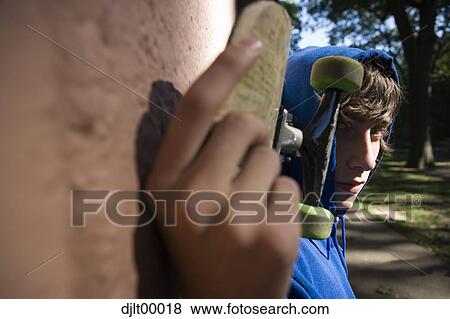 Close up of teenager with skateboard View Large Photo Image Stock Photo - Close up of teenager with skateboard. Fotosearch