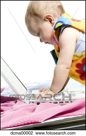 Stock Image - Closeup of a baby with laptop. Fotosearch