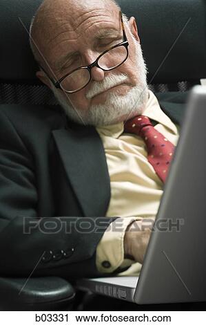 Stock Image - Closeup of businessman in office sleeping. Fotosearch