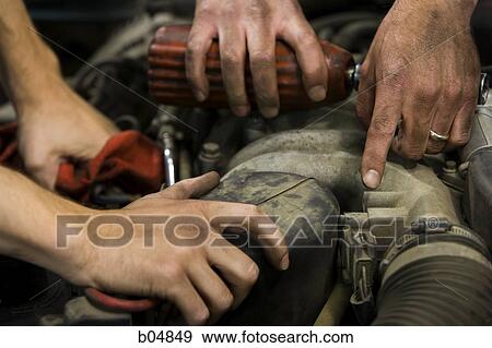 Closeup of four male hands fixing car View Large Photo Image Stock Photo - Closeup of four male hands fixing car. Fotosearch