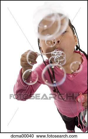 Stock Image - Closeup of girl blowing water bubbles. Fotosearch