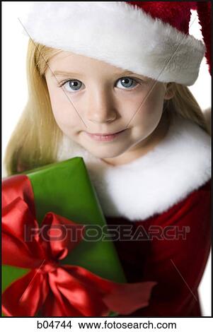 Closeup of girl in santa hat holding Christmas present View Large Photo Image Picture - Closeup of girl in santa hat holding Christmas present. Fotosearch
