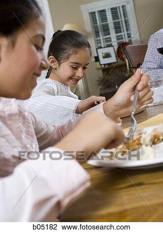 Closeup of girls at dinner table eating View Large Photo Image Stock Image - Closeup of girls at dinner table eating. Fotosearch