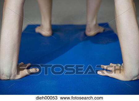 Stock Image - Closeup of hands on yoga mat. Fotosearch