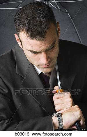 Stock Image - Closeup of man with umbrella. Fotosearch