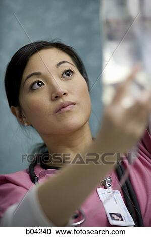 Stock Image - Closeup of nurse adjusting IV bag. Fotosearch