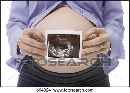Closeup of pregnant belly with ultrasound photo View Large Photo Image Picture - Closeup of pregnant belly with ultrasound photo. Fotosearch
