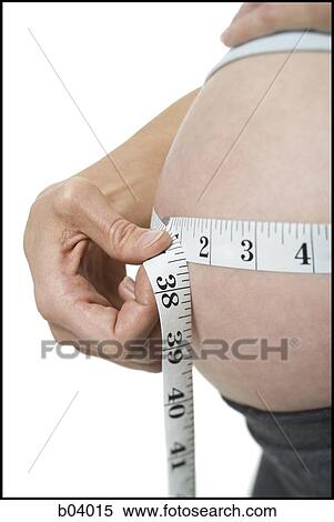Closeup of pregnant woman measuring belly View Large Photo Image Stock Photography - Closeup of pregnant woman measuring belly. Fotosearch