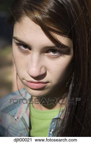 Stock Image - Closeup of teenage girl with a snarl. Fotosearch