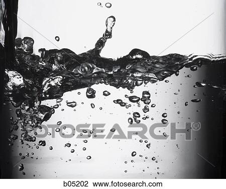 Stock Image - Closeup of water pouring into glass. Fotosearch