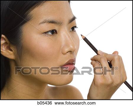 Closeup of woman applying eyeliner View Large Photo Image Stock Photograph - Closeup of woman applying eyeliner. Fotosearch