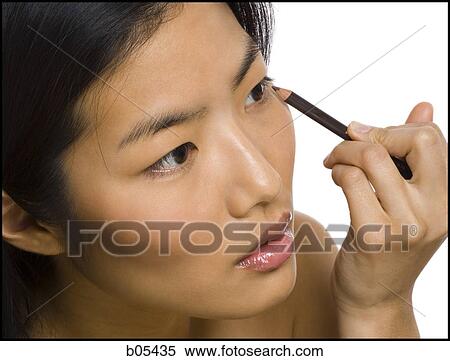 Closeup of woman applying eyeliner View Large Photo Image Stock Photography - Closeup of woman applying eyeliner. Fotosearch