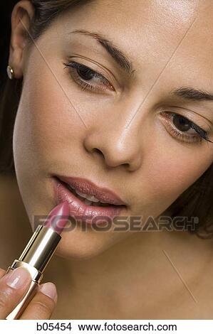 Closeup of woman applying lipstick View Large Photo Image Picture - Closeup of woman applying lipstick. Fotosearch