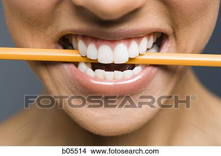 Picture - Closeup of woman biting pencil. Fotosearch