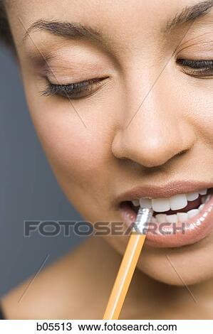 Closeup of woman biting pencil View Large Photo Image Stock Image - Closeup of woman biting pencil. Fotosearch