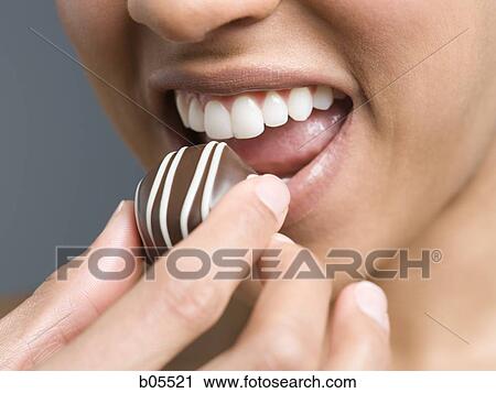 Closeup of woman eating chocolate View Large Photo Image Stock Image - Closeup of woman eating chocolate. Fotosearch