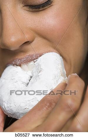 Closeup of woman eating powdered donut View Large Photo Image Stock Photo - Closeup of woman eating powdered donut. Fotosearch