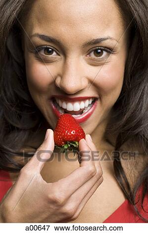 Stock Photo - Closeup of woman eating strawberry. Fotosearch