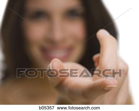 Stock Photo - Closeup of woman holding contact lens. Fotosearch