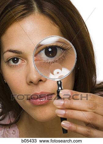 Closeup of woman holding magnifying glass to eye View Large Photo Image Stock Image - Closeup of woman holding magnifying glass to eye. Fotosearch