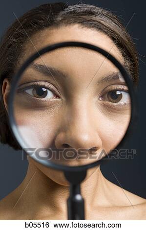 Closeup of woman holding magnifying glass to eyes View Large Photo Image Stock Photograph - Closeup of woman holding magnifying glass to eyes. Fotosearch