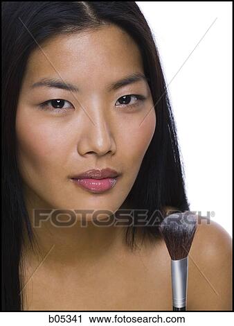 Stock Image - Closeup of woman with makeup brush. Fotosearch