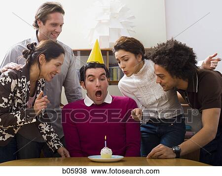 Co-workers around a birthday cupcake View Large Photo Image Stock Photo - Co-workers around a birthday cupcake. Fotosearch