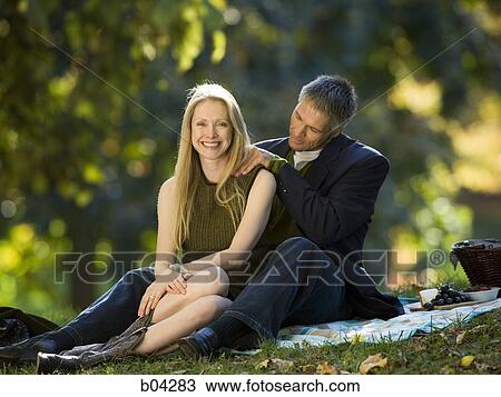 Stock Image - Couple having picnic outdoors. Fotosearch