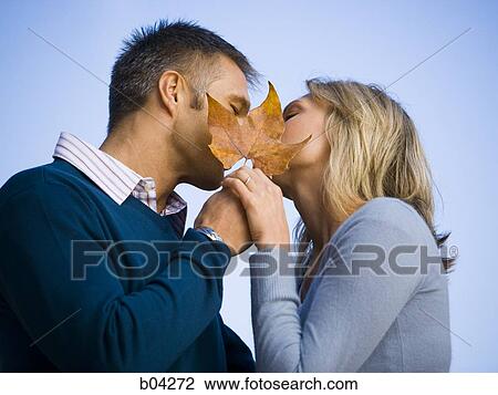 Couple kissing behind leaf View Large Photo Image Stock Image - Couple kissing behind leaf. Fotosearch