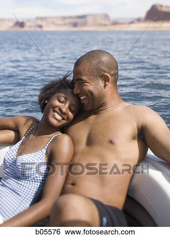 Stock Photograph - Couple on boat laughing. Fotosearch