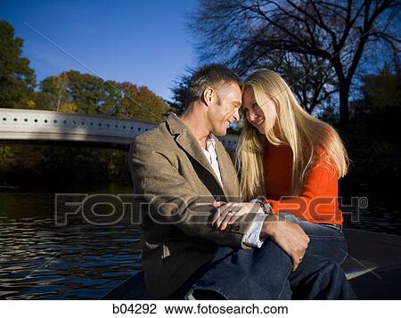 Couple sitting by water View Large Photo Image Stock Image - Couple sitting by water. Fotosearch