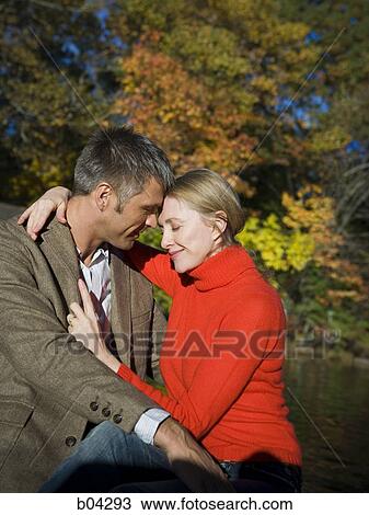 Couple sitting by water View Large Photo Image Stock Image - Couple sitting by water. Fotosearch