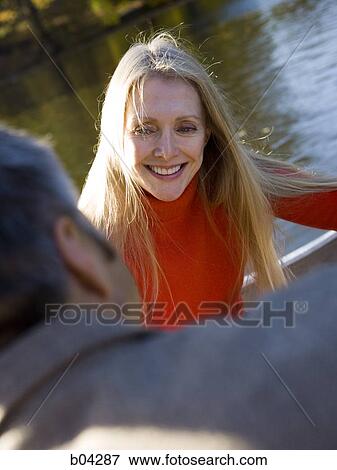 Stock Photo - Couple sitting by water. Fotosearch