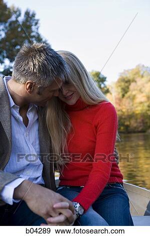 Stock Photo - Couple sitting by water. Fotosearch