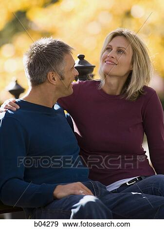 Couple sitting outdoors View Large Photo Image Stock Photo - Couple sitting outdoors. Fotosearch