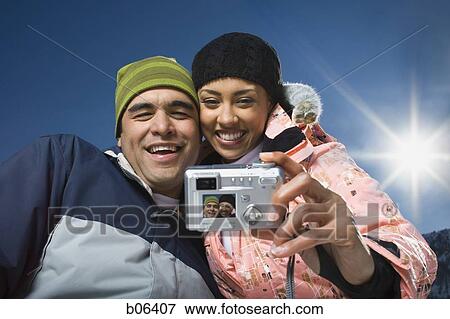 Stock Photo - Couple using a camera outside. Fotosearch