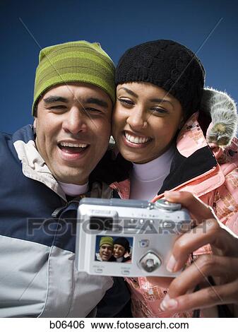 Couple using a camera outside View Large Photo Image Stock Photograph - Couple using a camera outside. Fotosearch