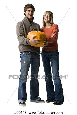 Couple with large pumpkin View Large Photo Image Stock Photo - Couple with large pumpkin. Fotosearch