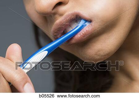 Stock Photograph - Detailed view of woman brushing teeth. Fotosearch